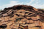 A large pile of rusty plates, used for railroad construction. Discarded or piled up for recycling.