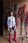 An organic farm in the Catskills. A person standing in a tack room in a stable.