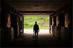 An organic farm in the Catskills. A man walking through a stable.