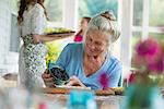 A family party in a farmhouse in the country in New York State. A mature woman holding bowl of fresh blackberries.