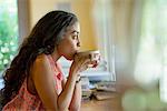 A woman sitting alone in a cafe, having coffee.