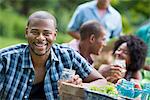 A group of adults and young people at a meal in the garden of a farmhouse.