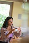 A woman having a cup of coffee.