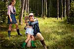 A man hugging a young child. A family on a woodland walk.