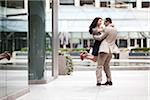 Excited couple embracing on ciity street sidewalk, Toronto, Ontario, Canada