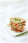 Stack of Smoked Salmon Quesadillas with Artichoke Hearts, Cream Cheese, Dill, Green Onions, Spinach, and Tomatoes on Whole Wheat Tortillas