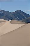 Hiker on the sand dunes, Great Sand Dunes National Park and Preserve, with Sangre Cristo Mountains in the background, Colorado, United States of America, North America