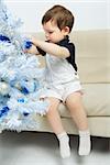 beautiful happy small kid decorate christmas tree