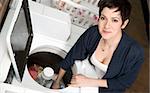 A woman pulls clothes from the washer at the laundromat