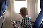 little boy in the plane looking out the window