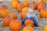 cute laughing boy having fun at the pumpkin patch