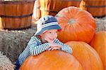 cute positive boy having fun at the pumpkin patch
