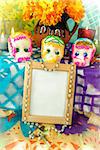 Traditional mexican day of the dead altar with blank photo frame, sugar skulls and candles