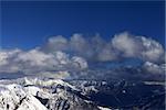 Winter sunlit mountains and sky with clouds. Caucasus Mountains, Georgia, view from ski resort Gudauri.