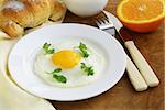 Continental breakfast - croissant, fried egg, toast and oranges