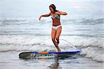 Young girl - the surfer in ocean. Bali. Indonesia