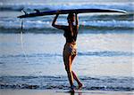 Woman-surfer with board on a coastline. Bali. Indonesia