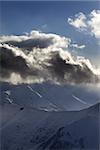 Evening mountain and sunlight clouds. View from ski resort Gudauri. Caucasus Mountains, Georgia.