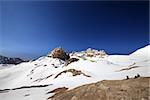 Two hikers on halt in snowy mountain. Turkey, Central Taurus Mountains, Aladaglar (Anti-Taurus), plateau Edigel (Yedi Goller). Wide angle view.