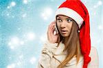 christmas portrait of sensual  young girl with winter style, long smooth hair and red santa claus hat talking on the smartphone.