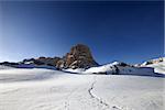 Snowy plateau and footpath against rock and blue sky in nice day. Turkey, Central Taurus Mountains, Aladaglar (Anti-Taurus), plateau Edigel (Yedi Goller). Wide-angle view.