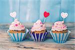 Photo of 3 cupcakes on wooden background