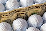 Dollars banknotes and white golf balls in open box in a shop