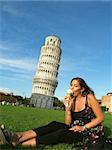 Beautiful girl enjoying an iceream in front of the leaning tower of Pisa