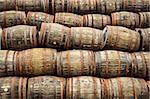 Stacked pile of old whisky and wine wooden barrels and casks