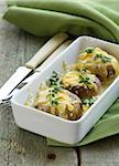 mushrooms baked with cheese, thyme served  on a wooden table