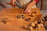 Closeup on young housewife chopping walnuts