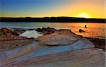 Looking at the sunrise from Bare Island, La Perouse, Sydney Australia. Beautiful sandstone rocks in the foreground.  Bracketed exposure with filter.