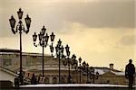 The lonely passer - by in evening square with lanterns. Moscow, Russia