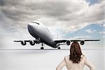 Composite image of businesswoman standing back to camera with hands on hips