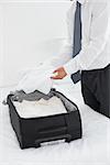 Side view mid section of a businessman unpacking luggage at a hotel bedroom