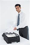 Side view portrait of a businessman unpacking luggage at a hotel bedroom