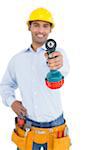 Portrait of a smiling handsome young handyman holding out drill against white background