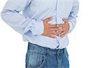 Close-up mid section of a casual man with stomach pain standing against white background