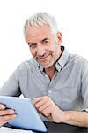 Portrait of a smiling mature businessman using digital tablet against white background
