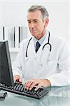 Concentrated male doctor using computer at the medical office