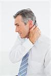 Side view of a mature man suffering from neck pain over white background