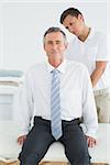 Male chiropractor examining mature man at office