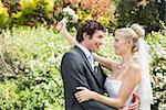 Romantic happy newlyweds embracing looking at each other in the countryside