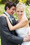 Romantic attractive newlywed couple hugging each other in the countryside