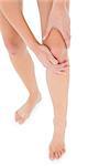 Close-up low section of a fit young woman with leg pain over white background