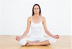 Full length of a toned young woman in lotus pose at a fitness studio