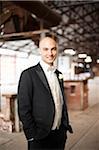 Close-up portrait of bridegroom standing in banquethall, smiling and looking at camera, Canada