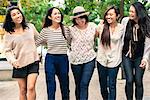 Group of five young women with arms around, smiling