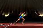 Young woman sprinting in stadium