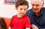 Young boy and grandfather in sitting room